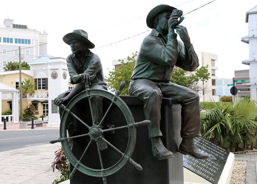 statue of mariners with ship wheel