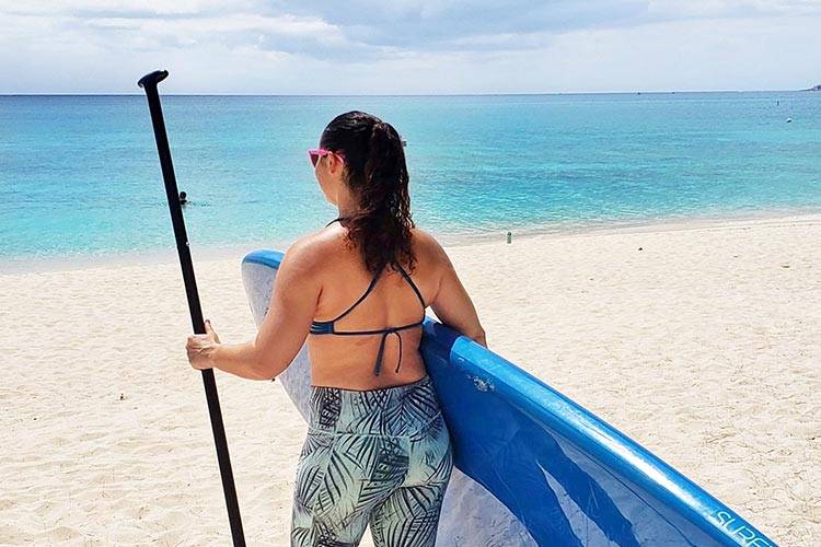 woman with paddleboard on Seven Mile Beach