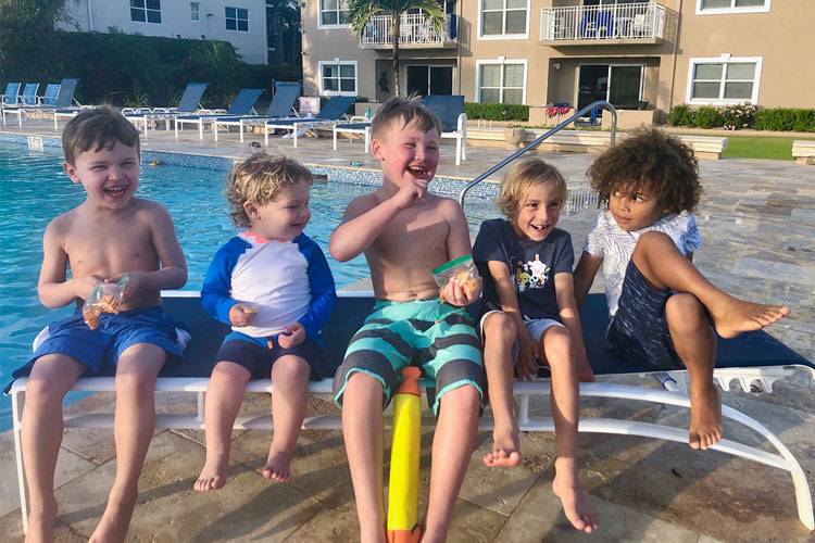 happy boys in front of tropical pool