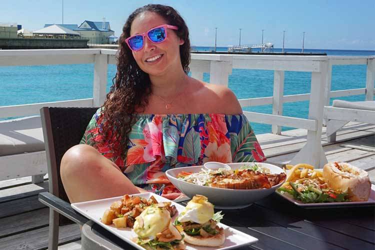 Chelsea Tennant in her element with a full food spread at a beachfront restaurant