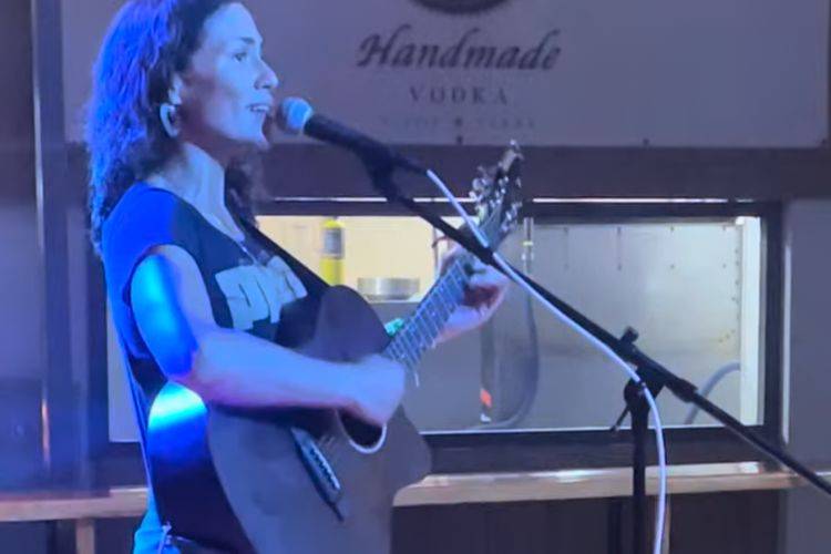 woman playing guitar and singing