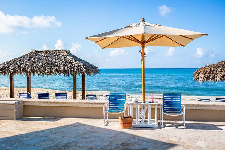 chairs under umbrella in front of seven mile beach