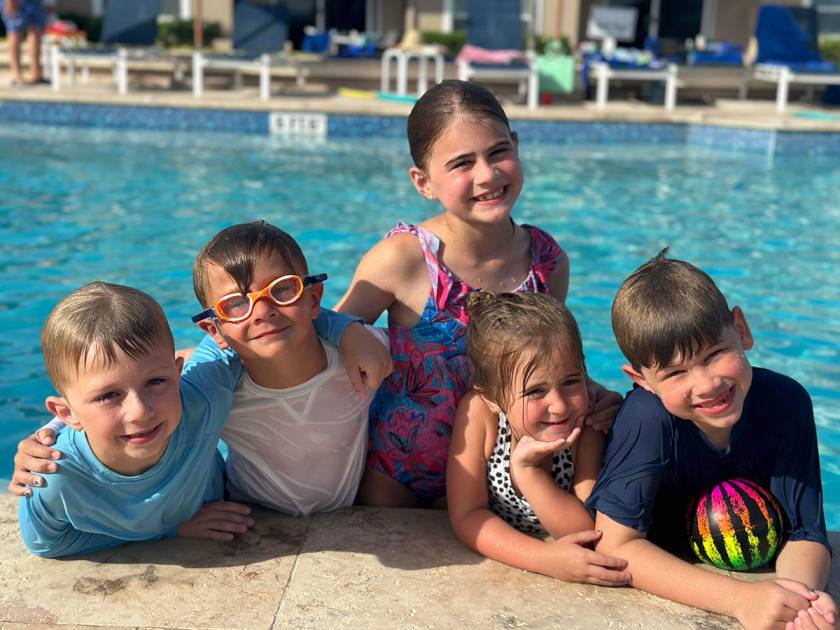 kids posing for photo in the pool