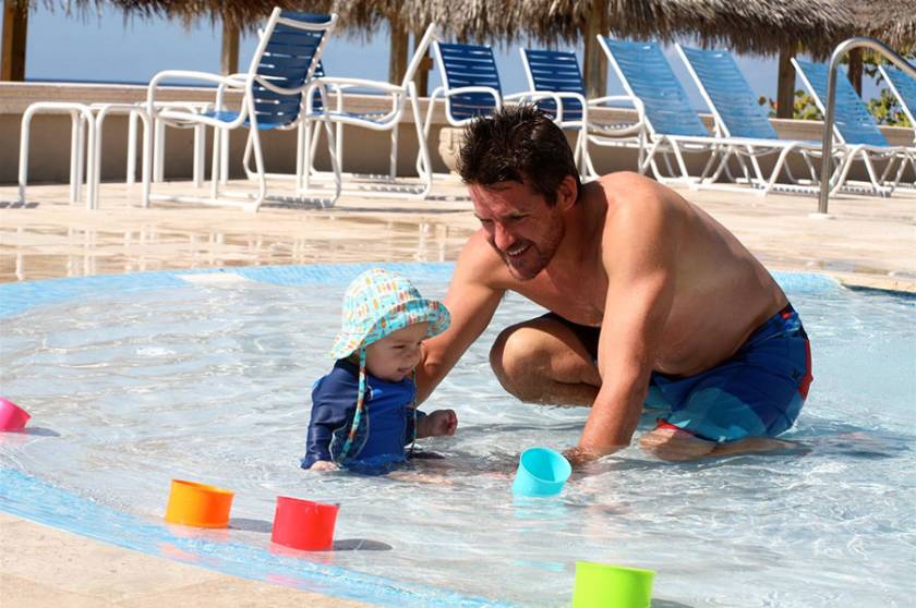 dad and son playing in child pool