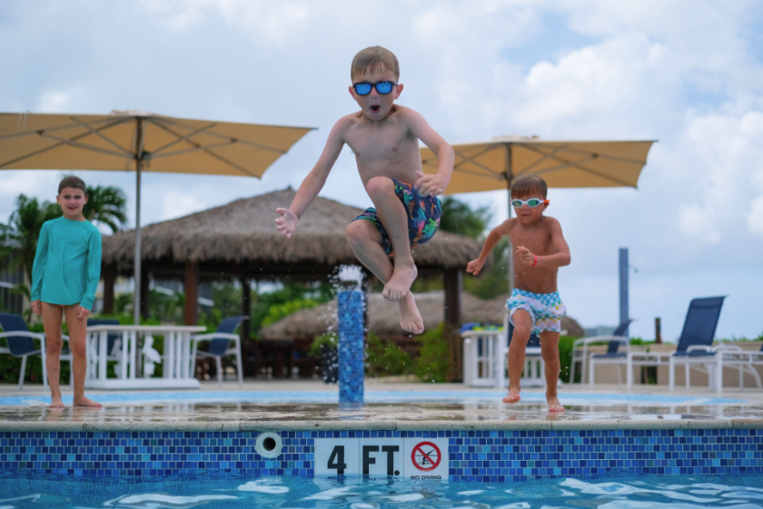 kid doing a cannonball into the pool